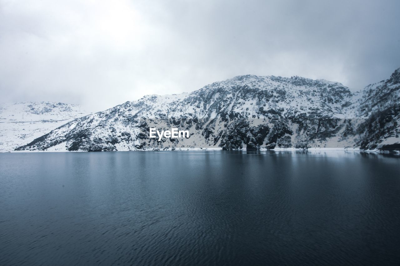 Scenic view of lake and snowcapped mountains against sky