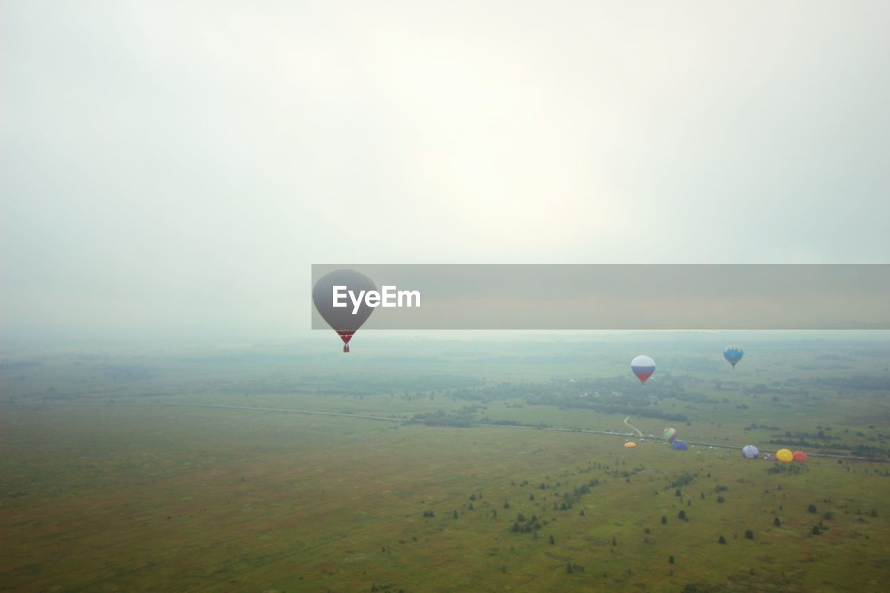 HOT AIR BALLOON FLYING OVER LANDSCAPE