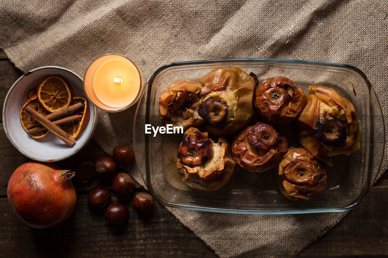 Roasted apples in a glass tray with chestnuts, cinnamon, orange and pomegranate