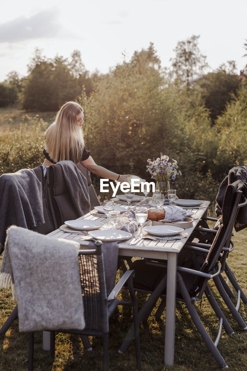 Woman preparing table for garden party