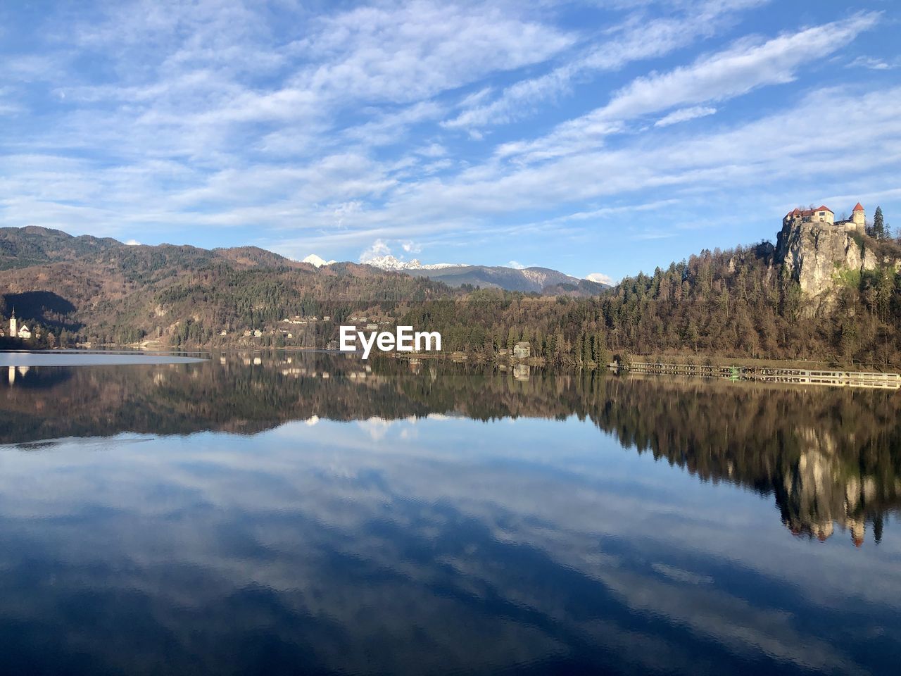 Scenic view of lake by mountains against sky