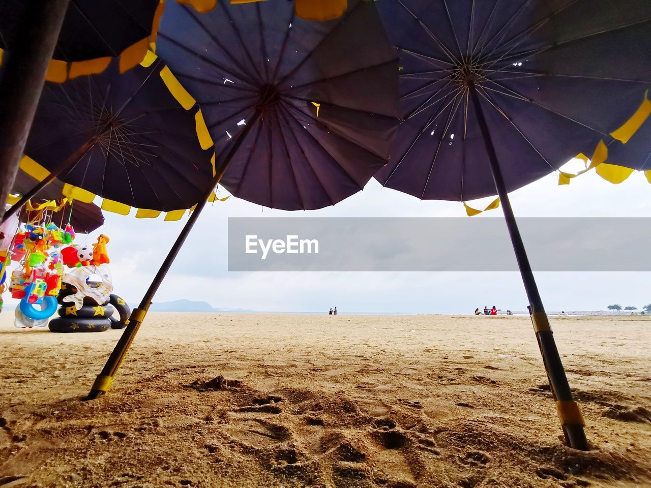 PARASOLS ON BEACH AGAINST SKY