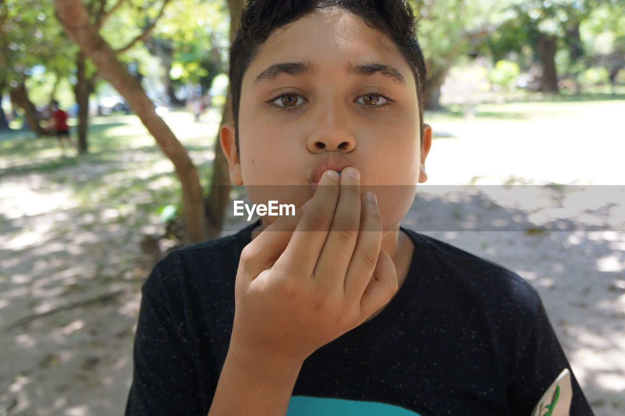 Portrait of boy standing at park