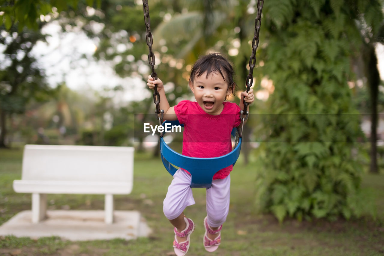 Girl playing on swing at park