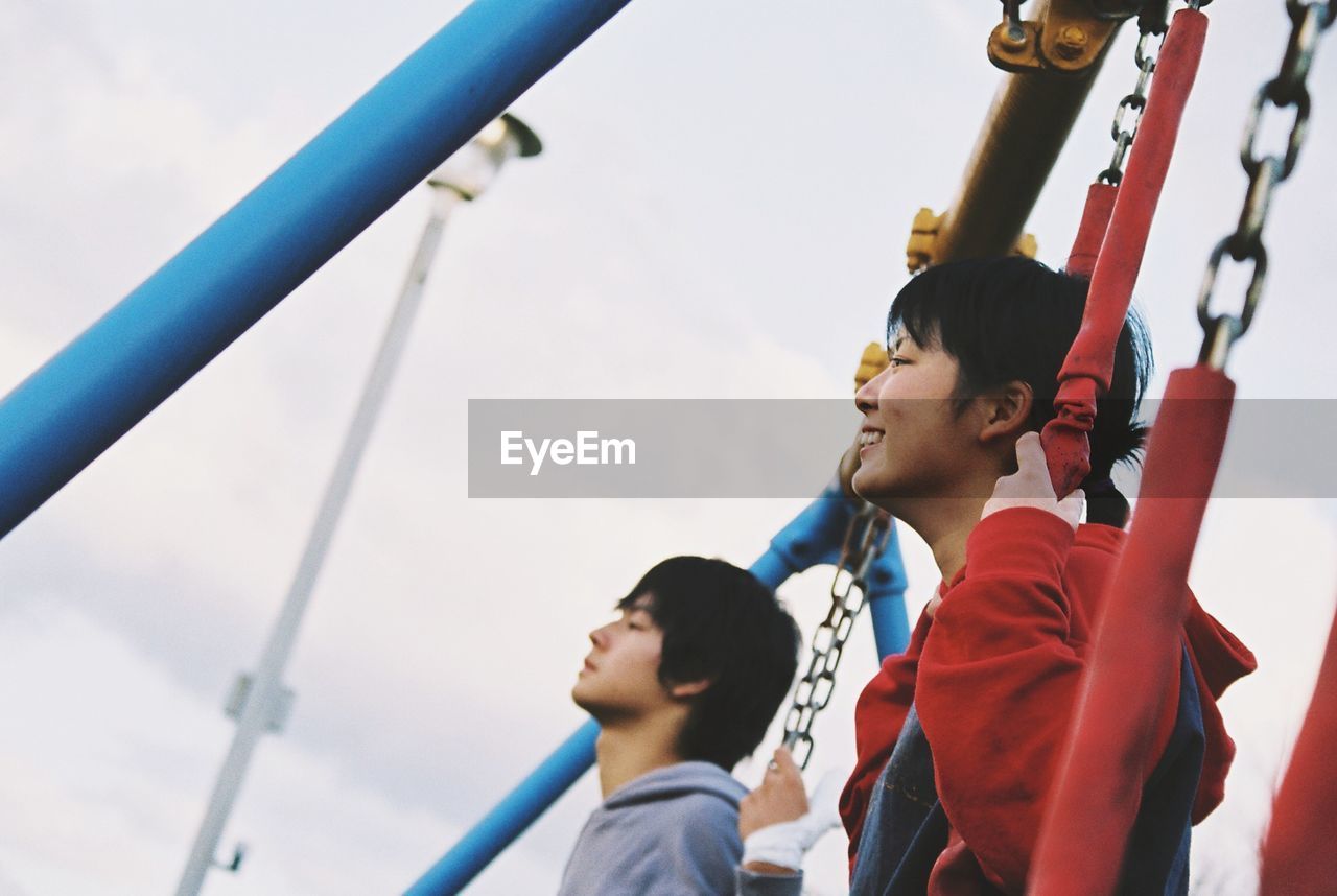 LOW ANGLE VIEW OF CHILDREN PLAYING ON PLAYGROUND