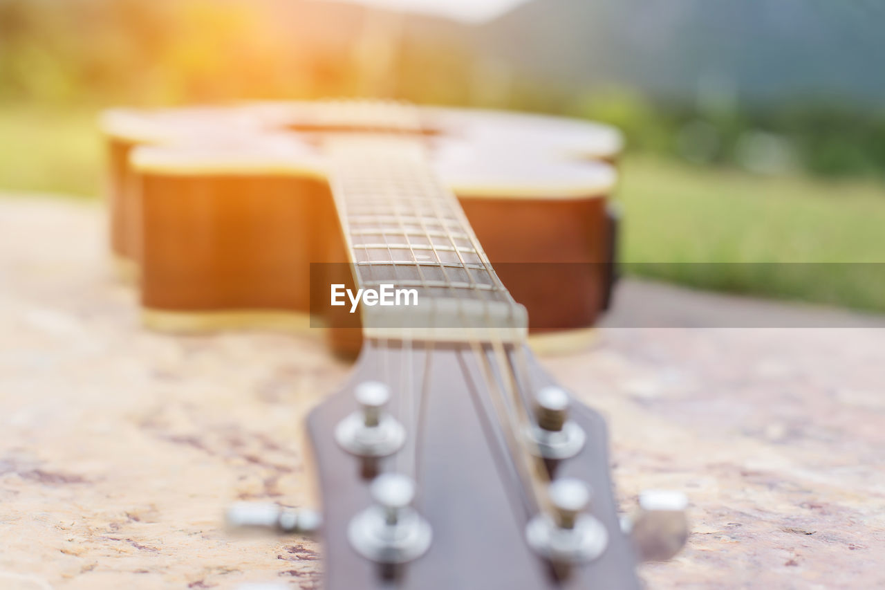 CLOSE-UP OF GUITAR ON TABLE AT CAFE