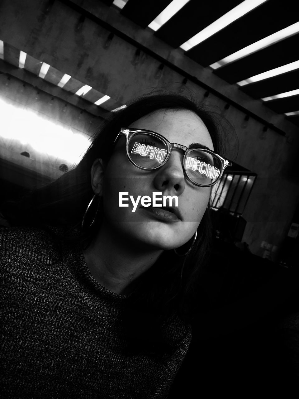 Woman wearing eyeglasses with reflection of text