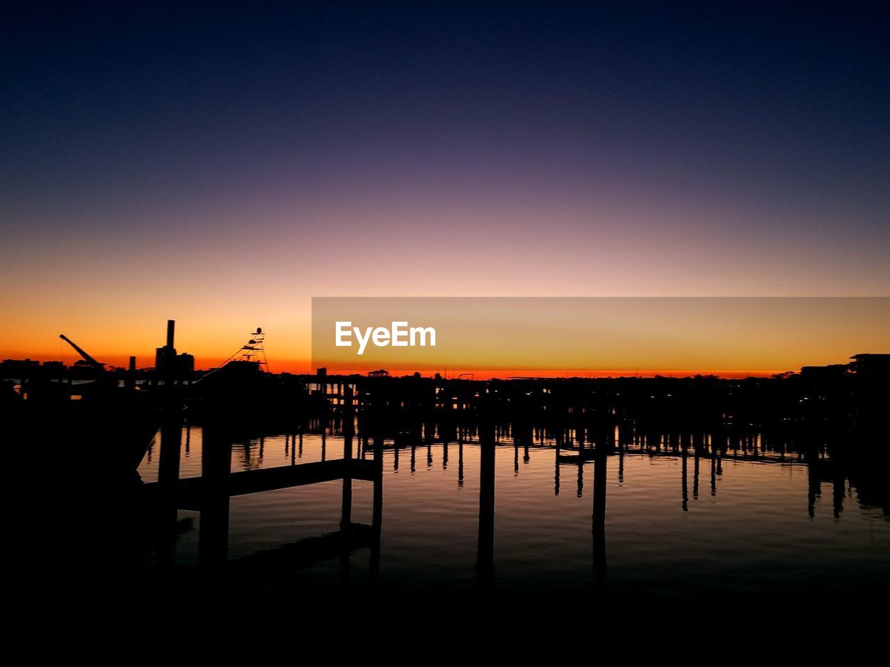 SILHOUETTE PIER ON SEA AGAINST ORANGE SKY