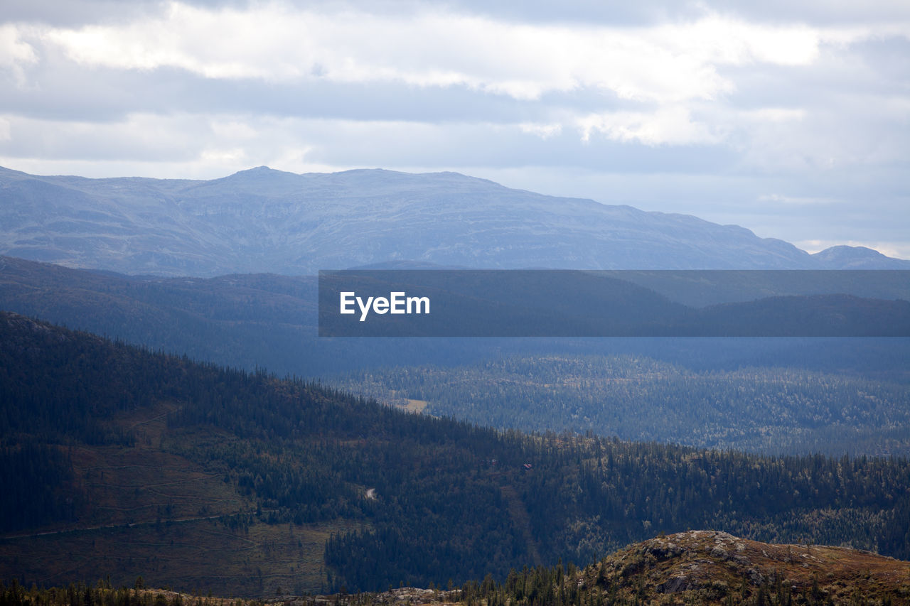 Scenic view of mountains against cloudy sky