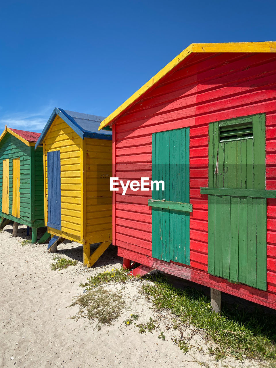 Multi colored beach houses in muizenberg near cape town, south africa against blue sky