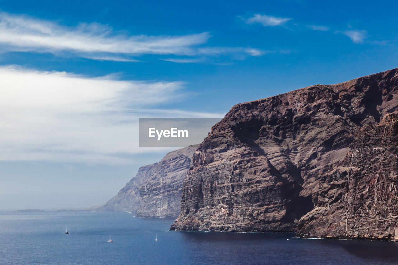 Scenic view of sea and mountains against sky