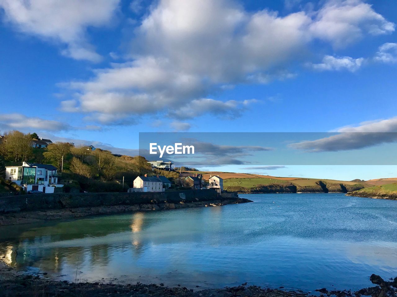 Scenic view of river by buildings against sky