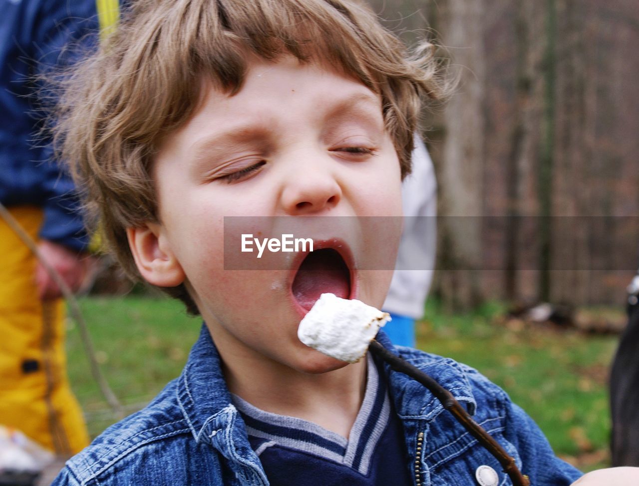 Close-up of boy having marshmallow outdoors