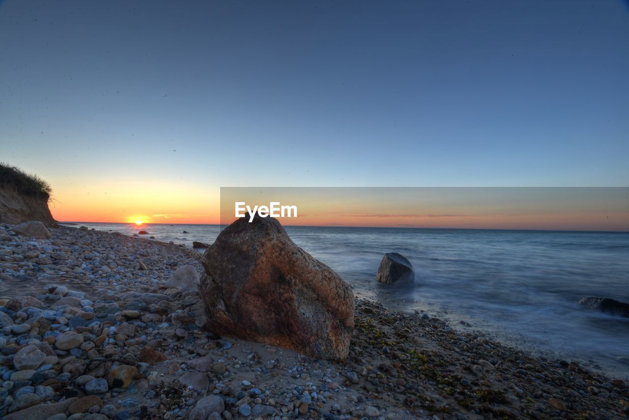 Scenic view of beach against sky during sunset