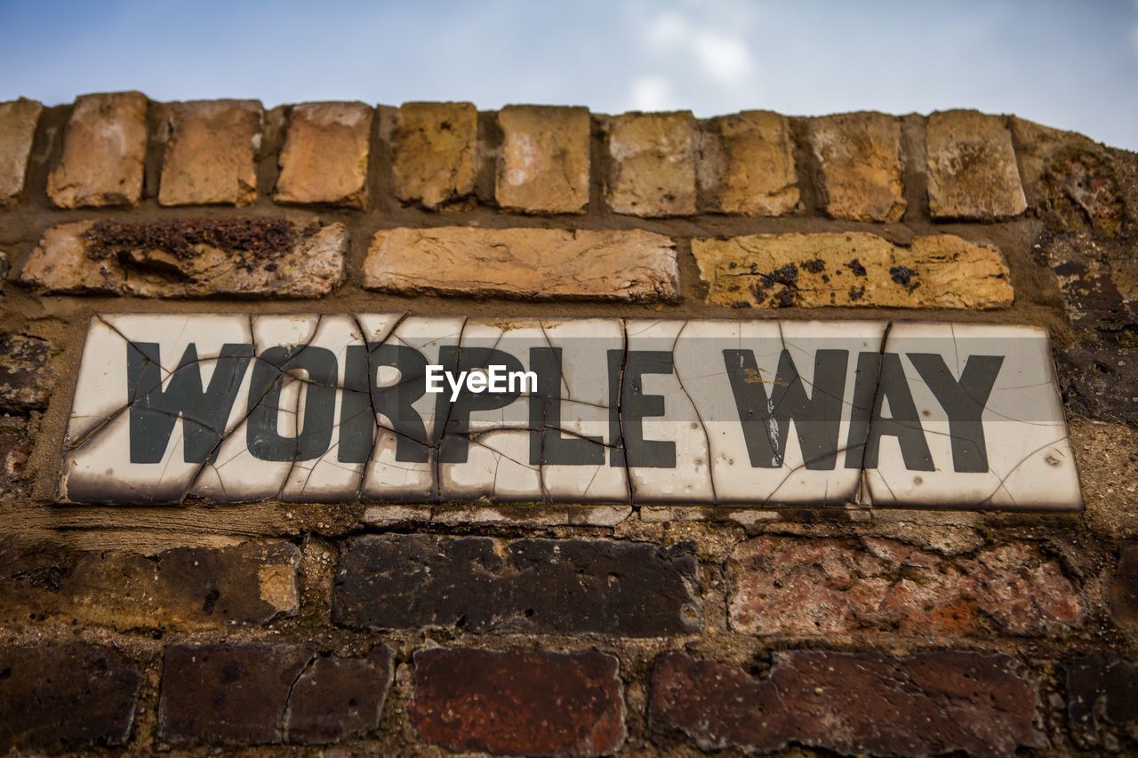 LOW ANGLE VIEW OF SIGN BOARD AGAINST SKY