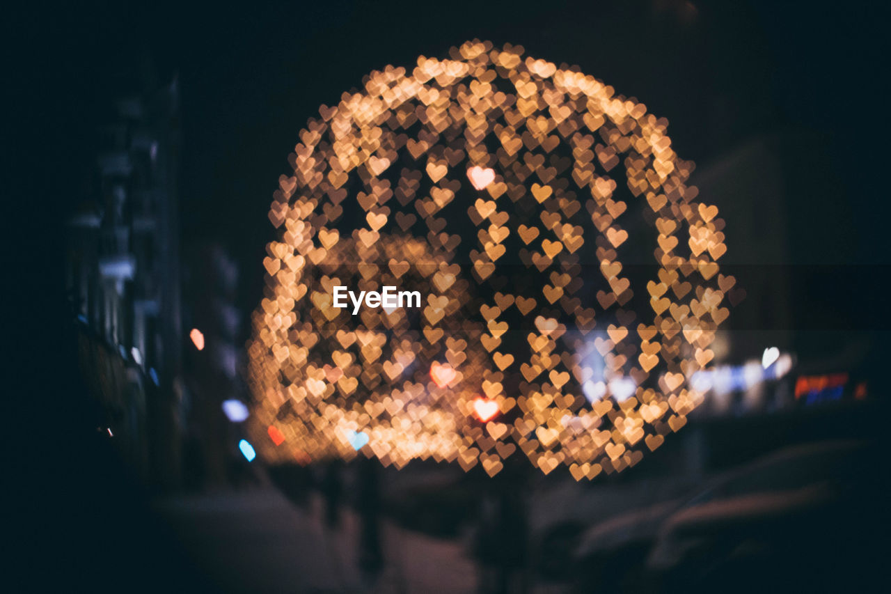 Hearts bokeh on the street of evening city in dark/ valentines style defocused lights background. 