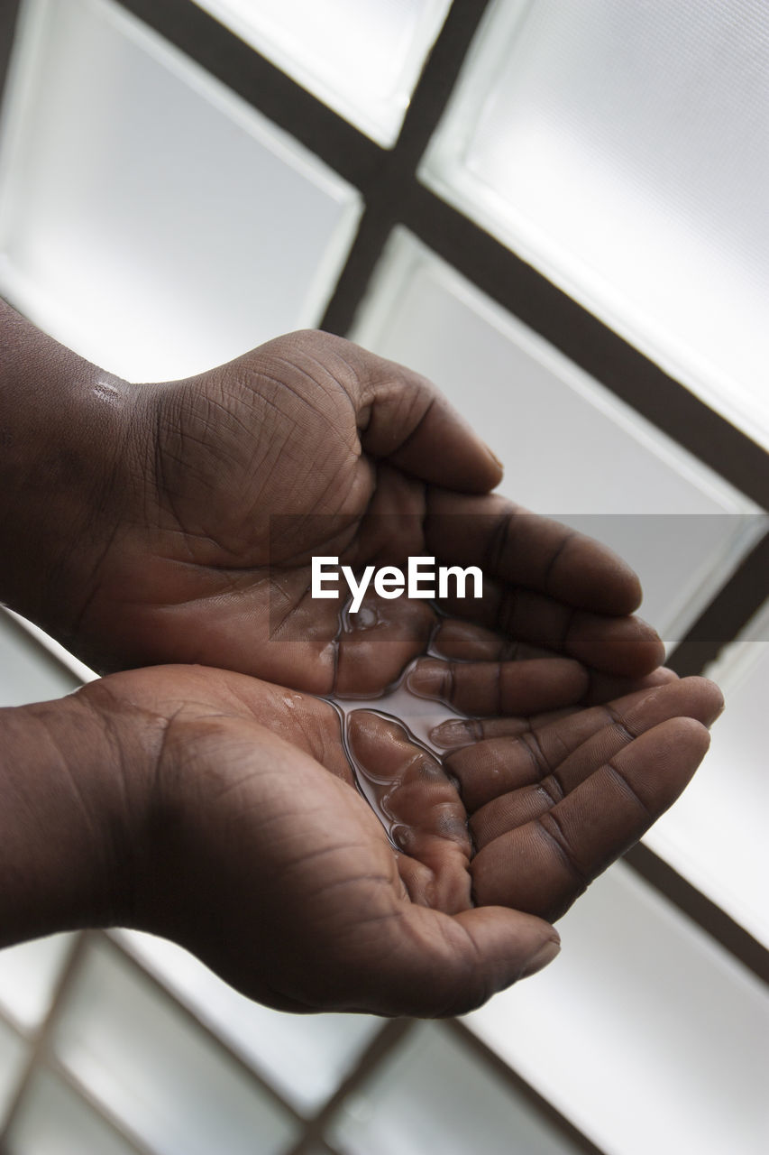 CLOSE-UP OF HUMAN HAND HOLDING MIRROR