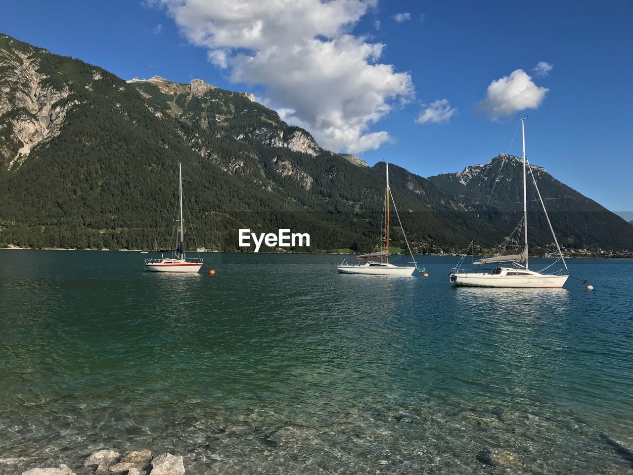 Sailboats in sea against sky