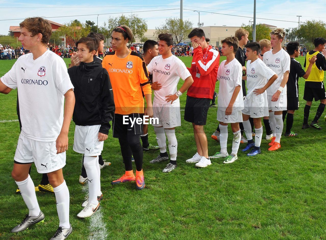 PEOPLE STANDING ON SOCCER FIELD