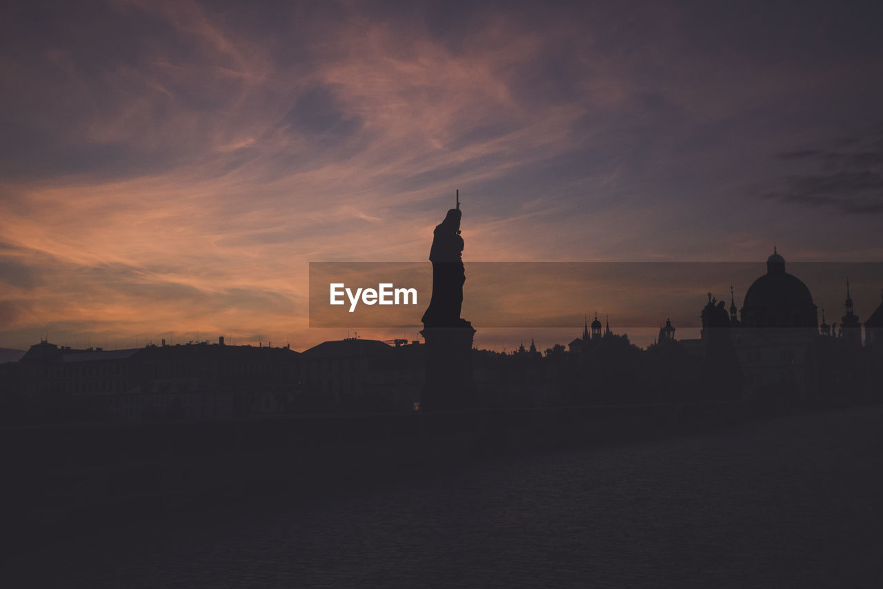 Silhouette statue against sky during sunset