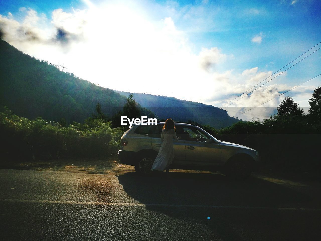 CARS ON ROAD WITH MOUNTAIN RANGE IN BACKGROUND