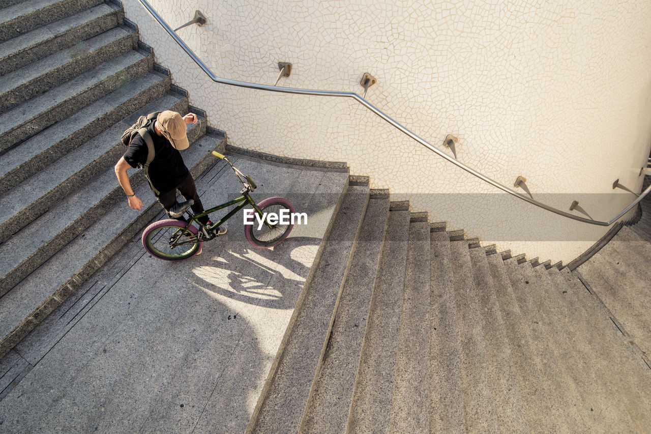 High angle view of man with bicycle on staircase