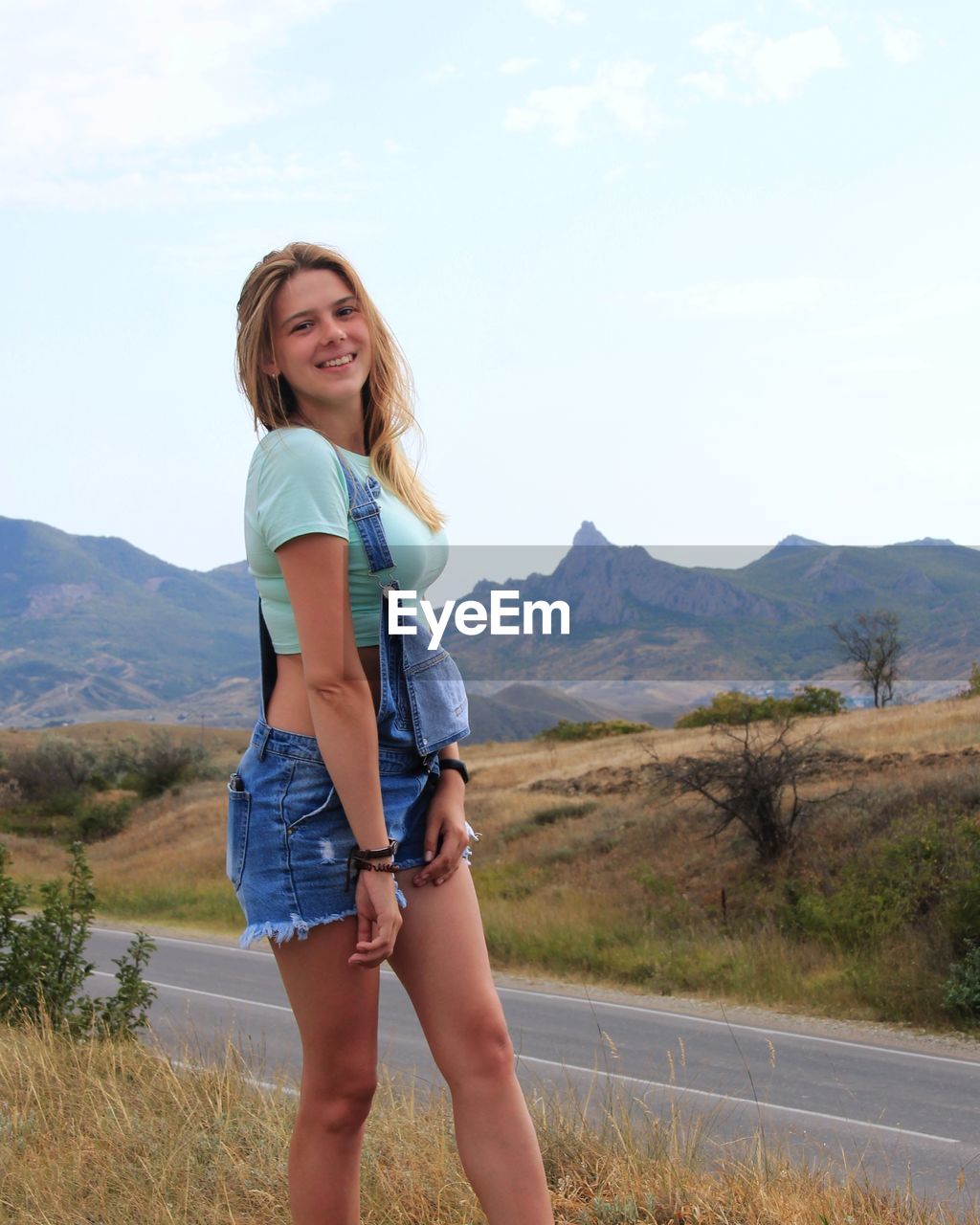 Portrait of smiling young woman standing on mountain