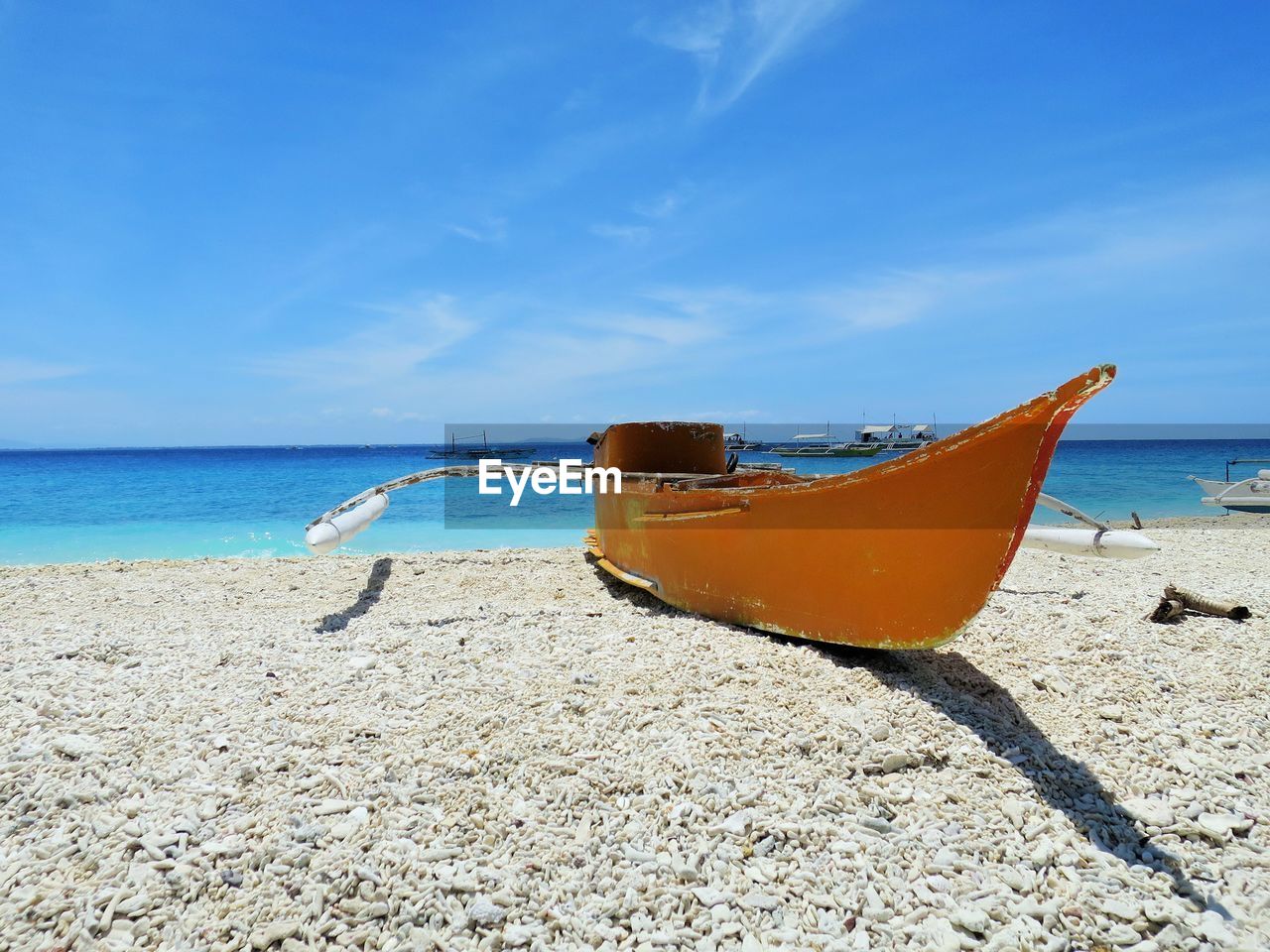 Boat moored on beach against sky