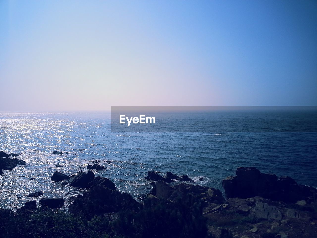 Scenic view of sea against clear blue sky