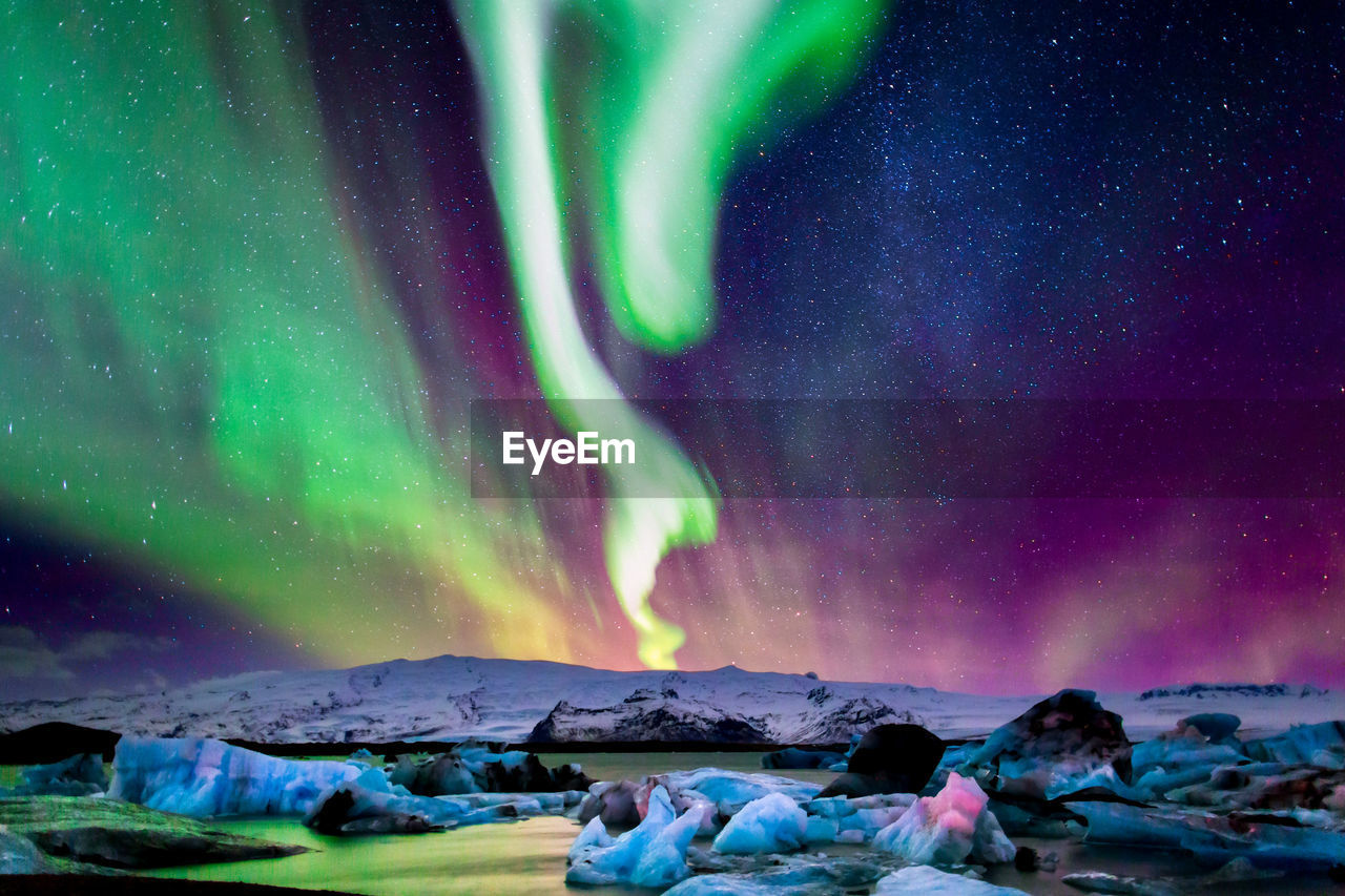 Scenic view of snowcapped mountain against sky at night