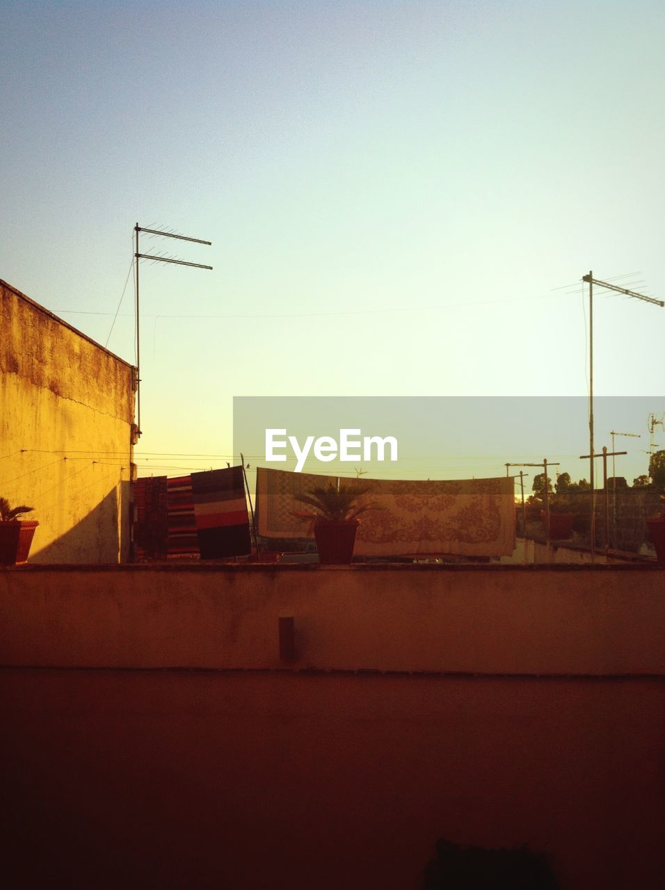 Clothesline hanging against sky seen through balcony