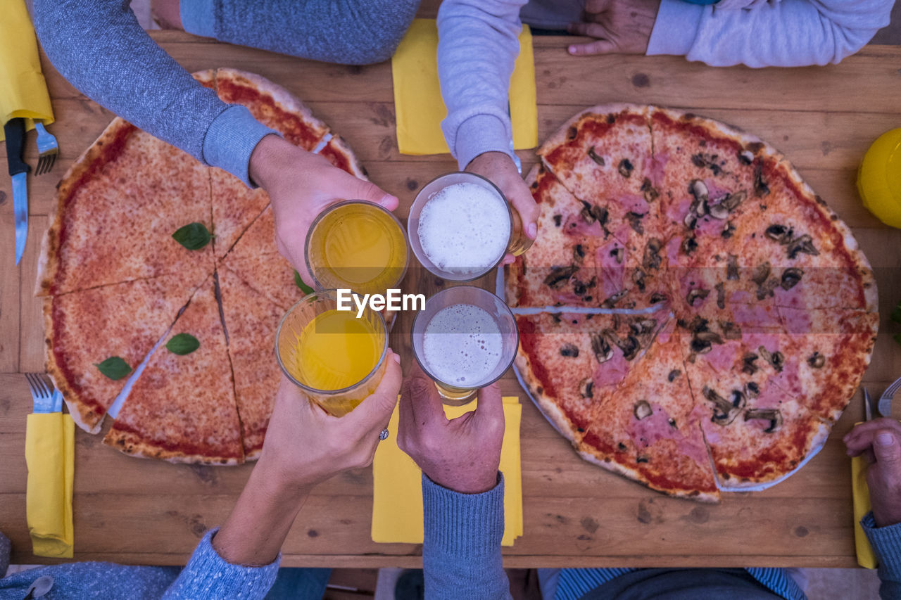 HIGH ANGLE VIEW OF WOMAN HOLDING PIZZA