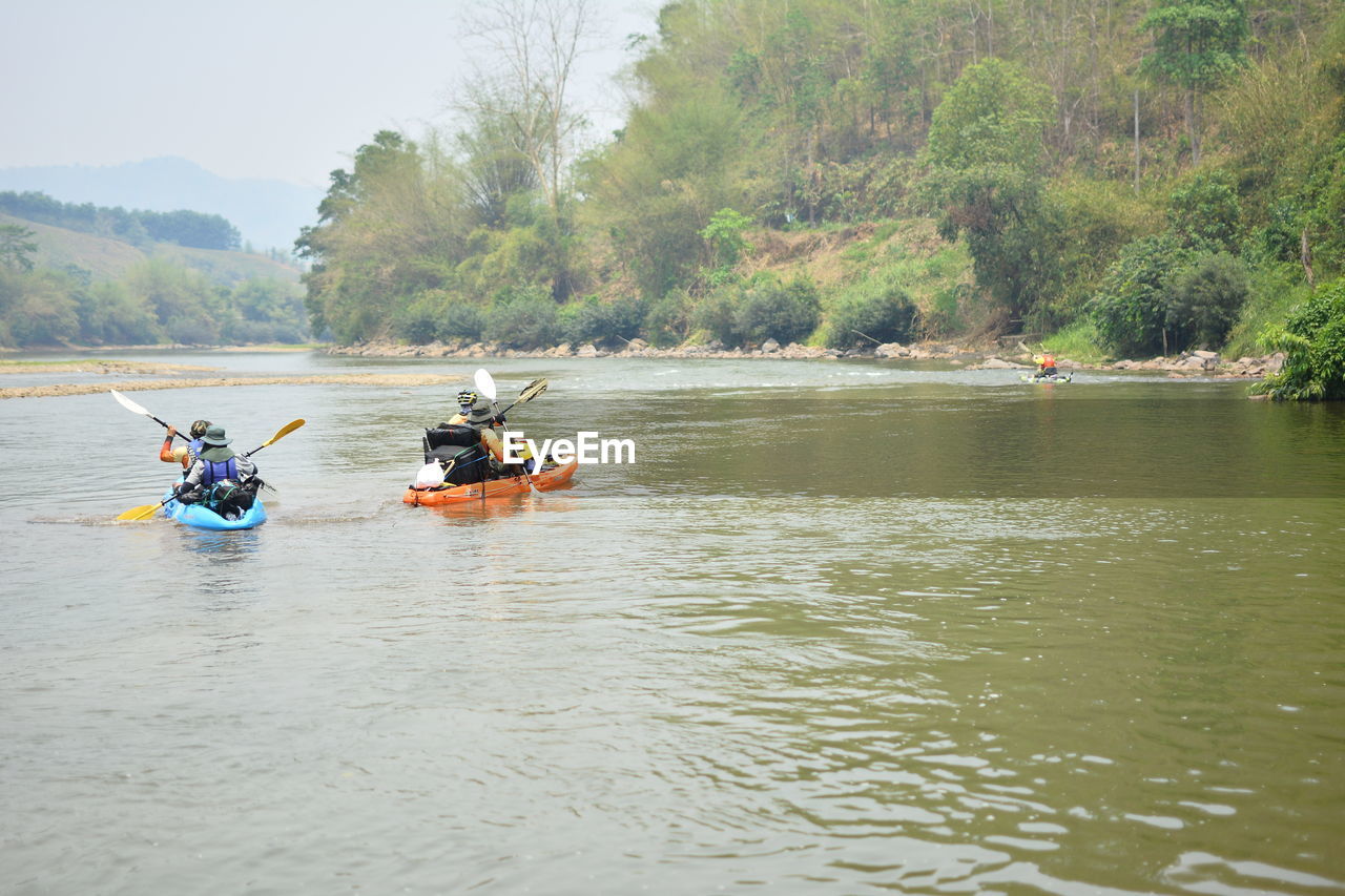 PEOPLE ON BOAT BY RIVER