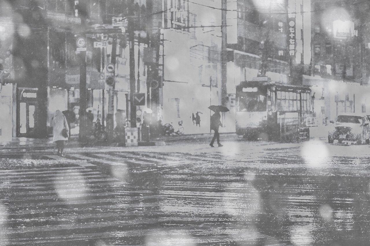 REFLECTION OF MAN ON WET STREET