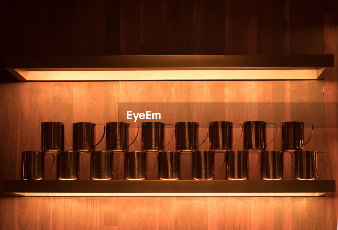 Mugs arranged side by side on shelf