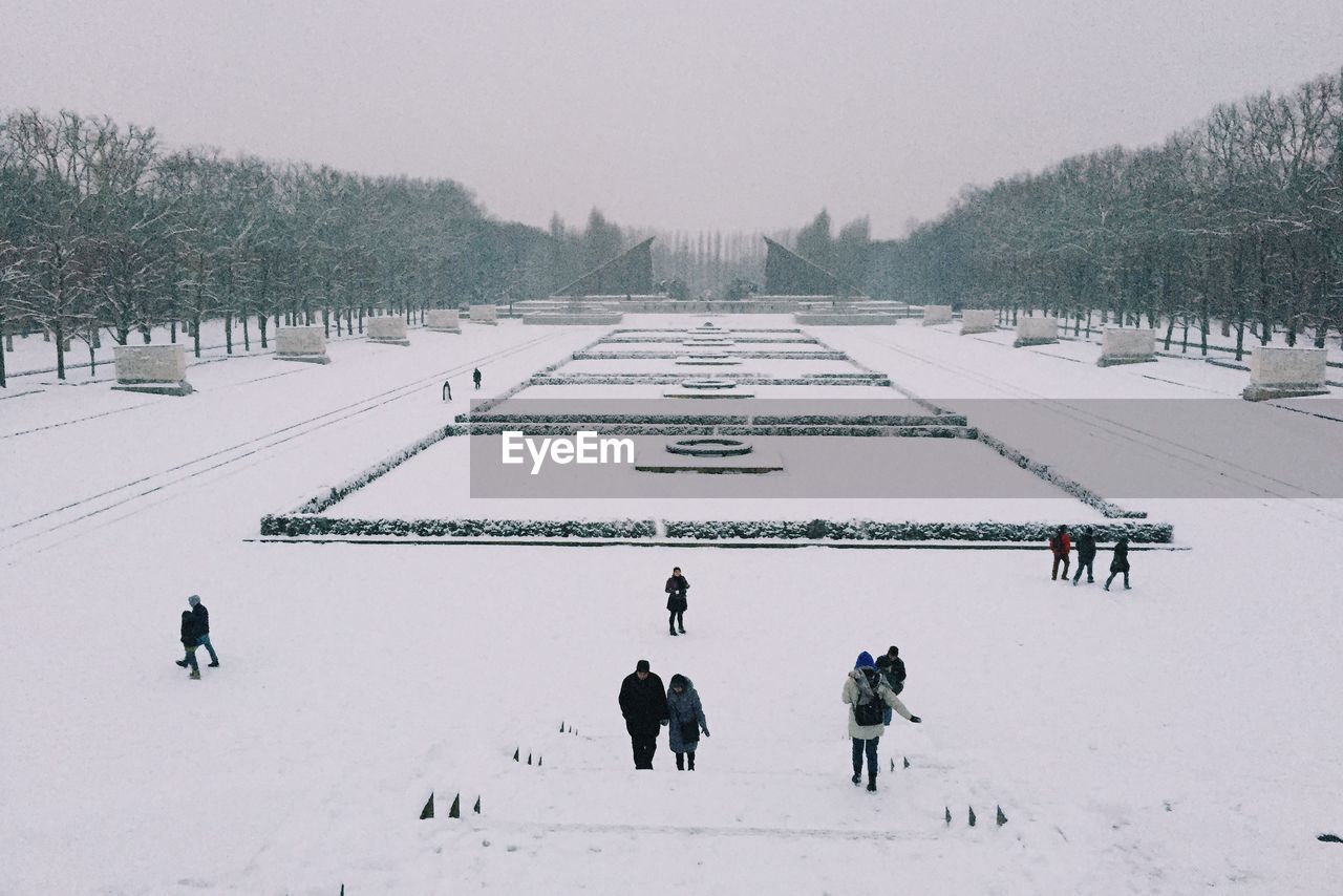 PERSON WALKING ON SNOW COVERED LANDSCAPE
