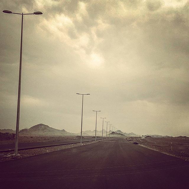 ROAD AGAINST CLOUDY SKY