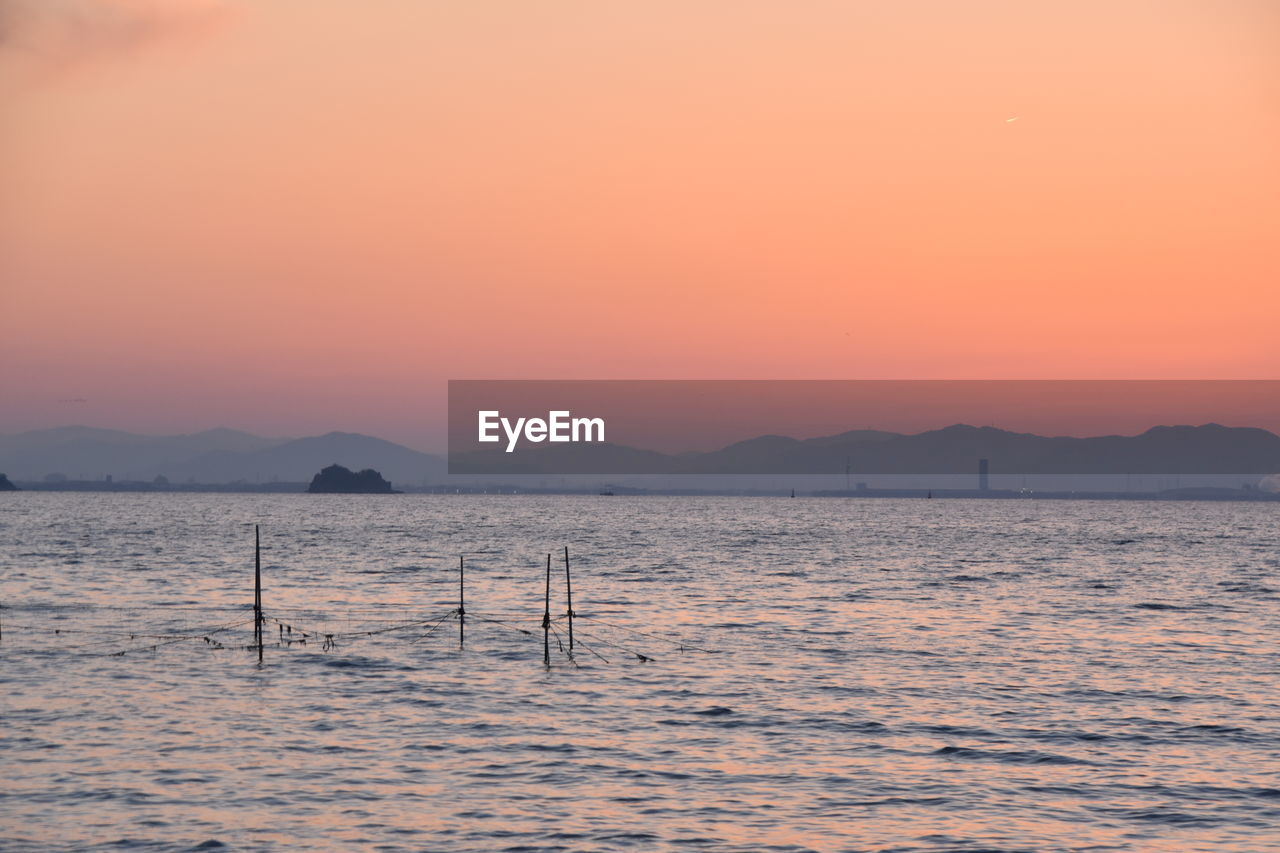 SCENIC VIEW OF SEA AGAINST SUNSET SKY