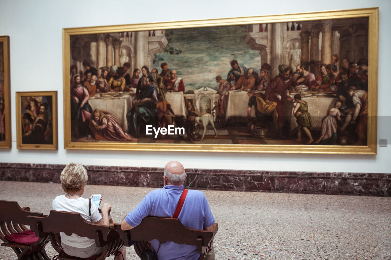 REAR VIEW OF PEOPLE AT MUSEUM AGAINST THE SKY