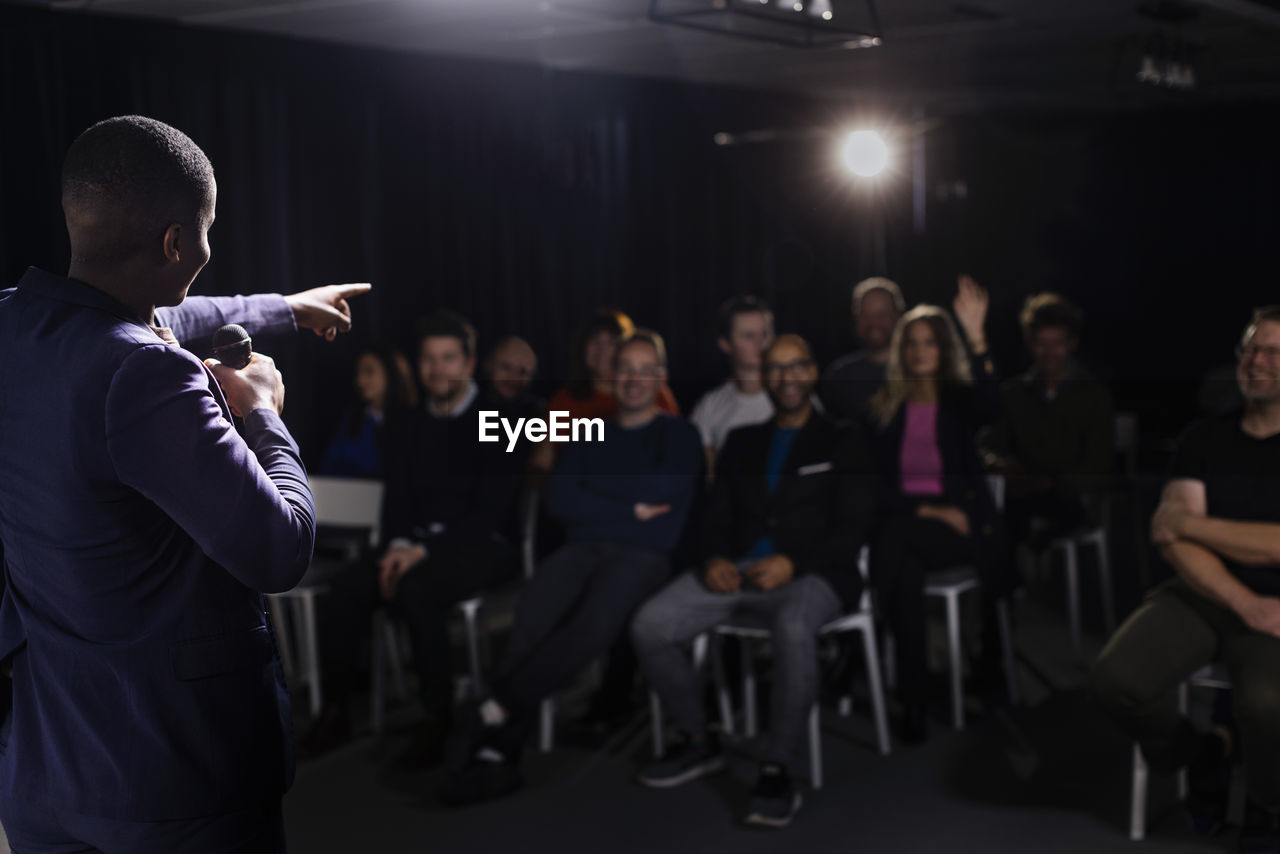 Tv show host pointing towards audience