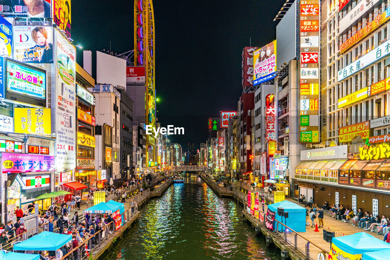 ILLUMINATED CITY BUILDINGS AT WATERFRONT