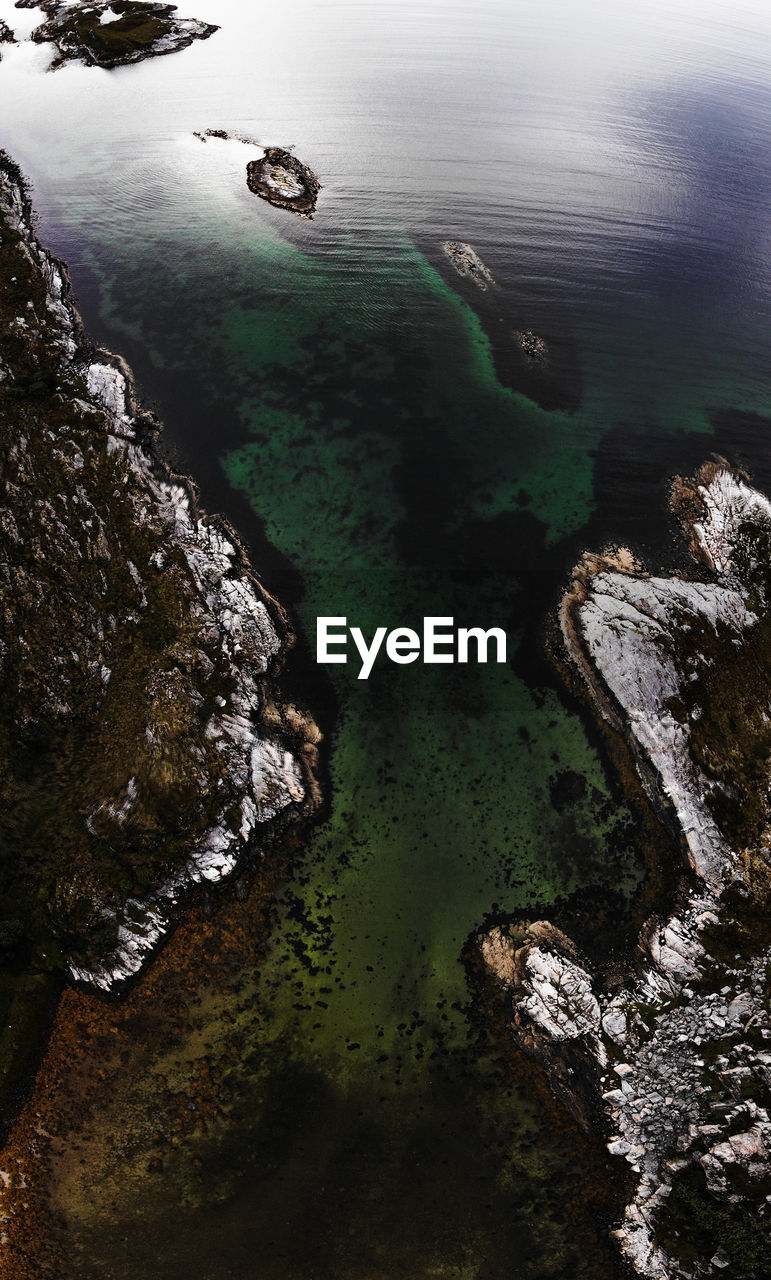 HIGH ANGLE VIEW OF ROCKS ON SEA