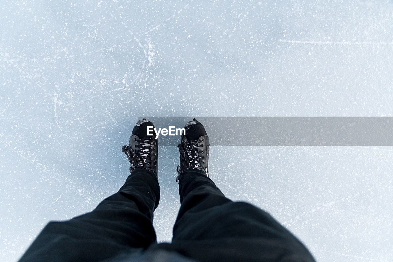 Low section of man standing on ice rink during winter