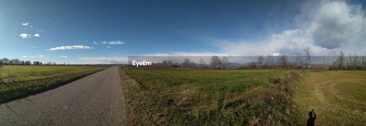 PANORAMIC VIEW OF ROAD AMIDST FIELD