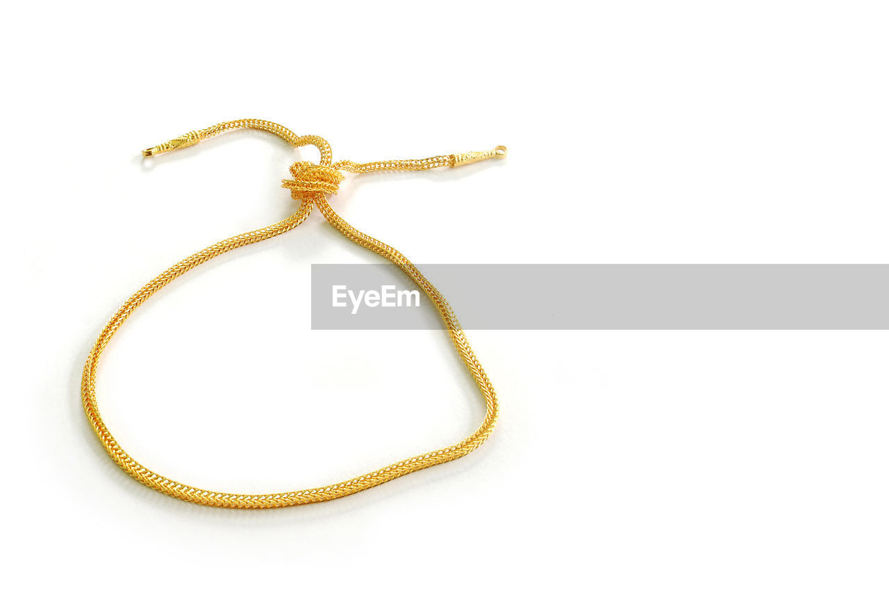 Close-up of gold chain against white background