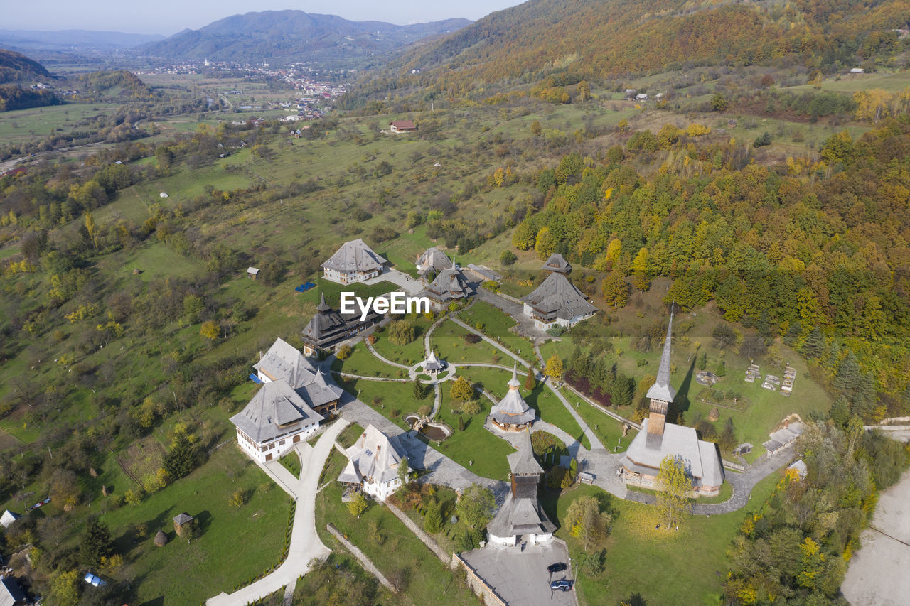 HIGH ANGLE VIEW OF TREES AND BUILDINGS AGAINST MOUNTAIN