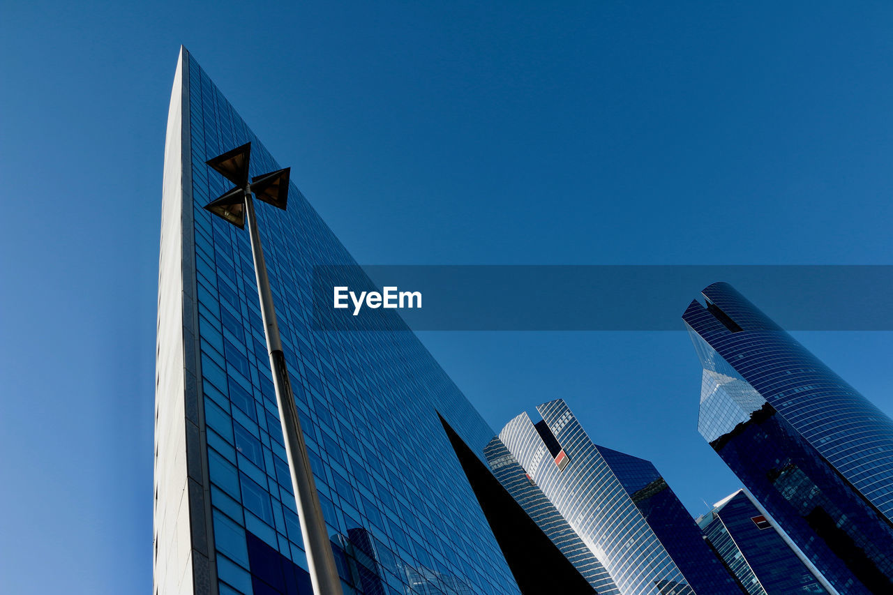 LOW ANGLE VIEW OF SKYSCRAPERS AGAINST BLUE SKY