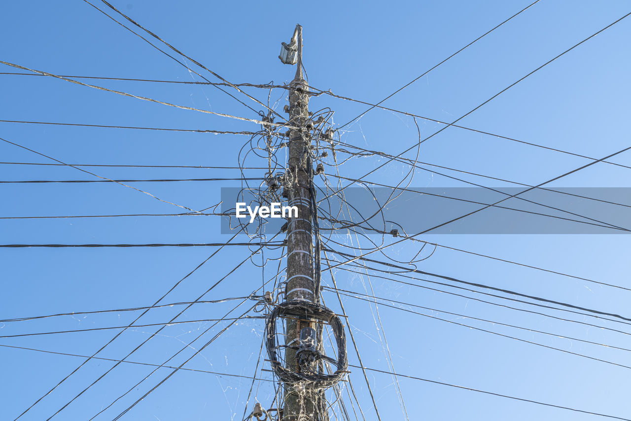technology, electricity, cable, electricity pylon, power generation, power supply, power line, tower, overhead power line, sky, transmission tower, outdoor structure, no people, nature, electrical supply, complexity, communication, low angle view, blue, clear sky, outdoors, outdoor power equipment, day, mast, line, sign