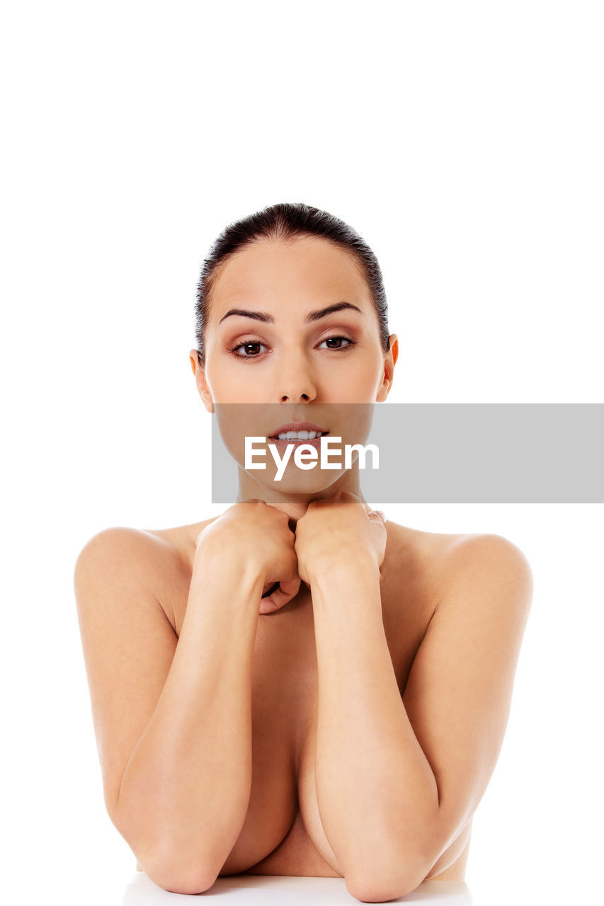 Portrait of smiling shirtless young woman against white background