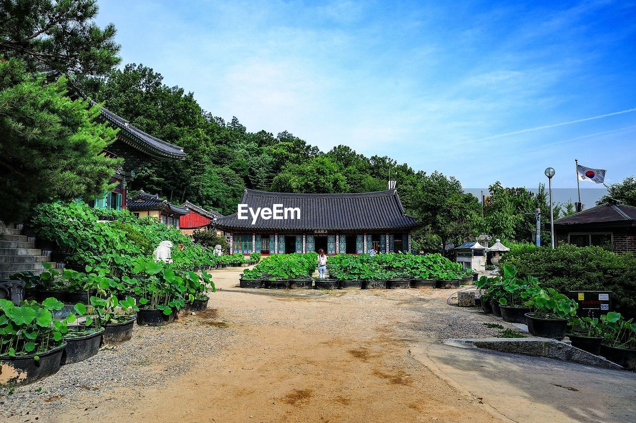 Built structure by trees against sky